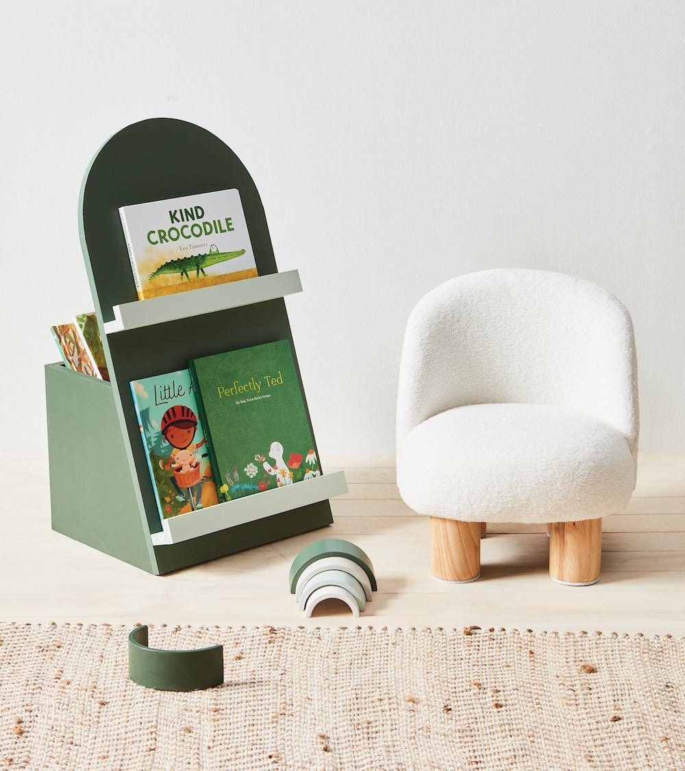 Full styled scene: arch-shaped green book holder, bouclé armchair, and Resene paint swatches